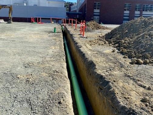 a green drain in a pit dug for it